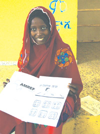 A health professional shows a chart with Coartem tablets in groups of four.