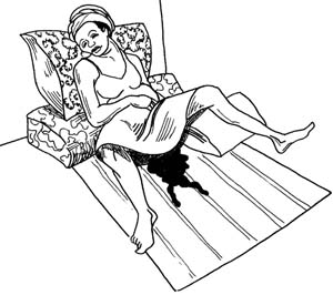 A woman is lying on a mat haemorrhaging. Blood covers the mat.