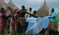 A group of people being shown how to use the bed net properly.