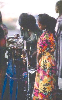 Women teaching children how to wash their hands and faces