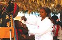 A child being given vitamin A drops by a HEP.