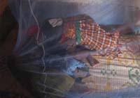 A mother and child sleeping under their new bed net.