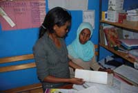 A woman and a health professional sit together in an office to talk.