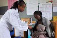A health professional is relaying a health message to a woman.