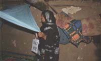 A woman hangs her bed net in her room.